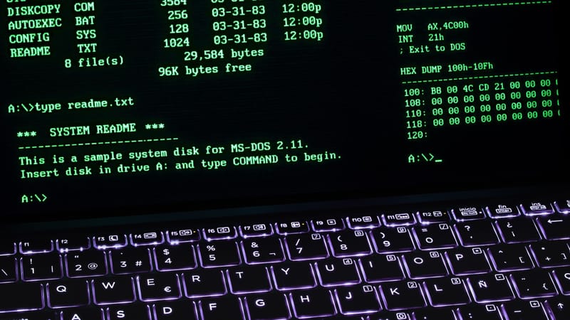 A classic MS-DOS terminal screen displayed on a laptop keyboard with vivid illumination.