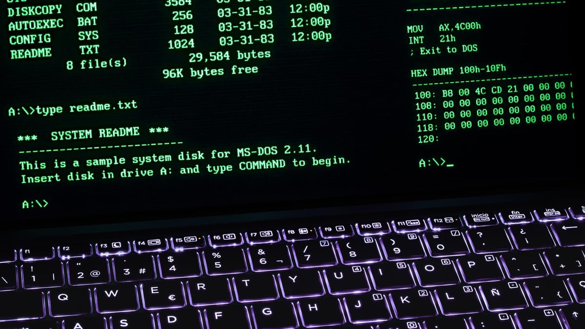 A classic MS-DOS terminal screen displayed on a laptop keyboard with vivid illumination.